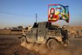 An Iraqi special forces vehicle carries a Shiite flag near Mosul in November.