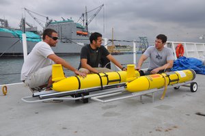 File - Daniel Braun, left, Eric Sanchez and David Barney, Systems Center Pacific engineers at Space and Naval Warfare Systems Command (SPAWAR), perform pre-deployment inspections on littoral battlespace sensing gliders aboard the Military Sealift Command oceanographic survey ship USNS Pathfinder