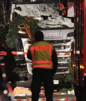 Police stand in front of a black lorry that ploughed through a Christmas market in Berlin.
