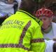 An ambulance officer comforts cyclists after a woman was killed on Mona Vale Road, Pymble.