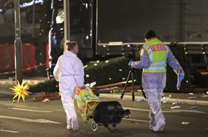 Forensic experts of the police investigate the crime scene after a truck ran into a crowded Christmas market and killed several people in Berlin, Germany