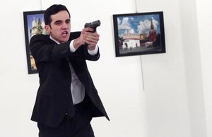 An unnamed gunman gestures after shooting the Russian Ambassador to Turkey, Andrei Karlov, at a photo gallery in Ankara, Turkey