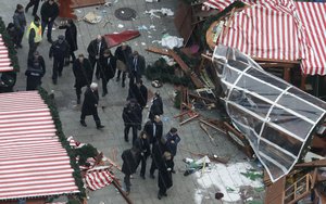 German Chancellor Angela Merkel, bottom center, visits the site of the attack in Berlin, Germany, Tuesday, Dec. 20, 2016, the day after a truck ran into a crowded Christmas market and killed several people.