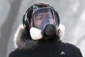 A man wearing a mask for protection against pollution exercise at Ritan Park during a heavily polluted day in Beijing.