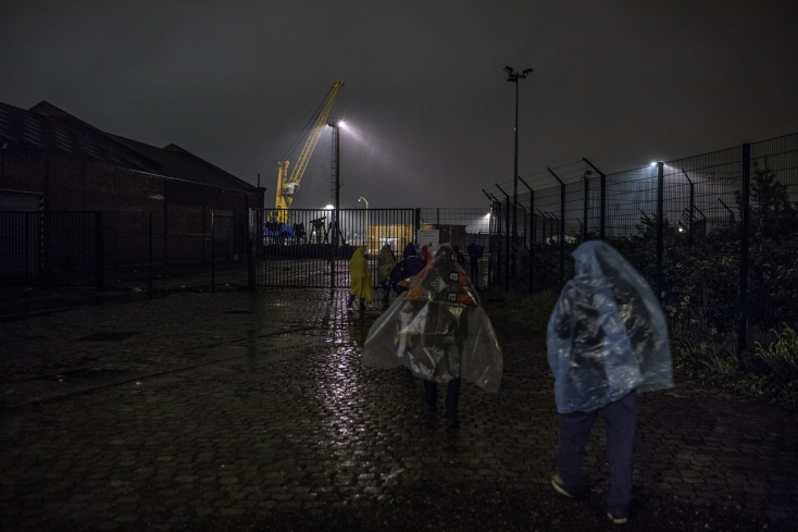 Refugees bringing their belongings to the new squat