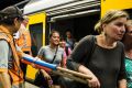 Commuters are escorted off a train that shut down due to a power outage at Wynyard Station