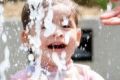 Anika, 2, plays in a water feature in Sydney. 