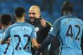 Manchester City manager Josep Guardiola congratulates his players after beating Arsenal 2-1 during the English Premier ...