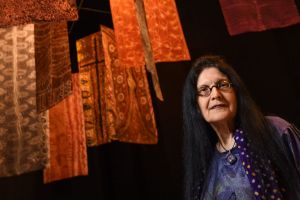 Senior curator of Indigenous art Judith Ryan with batik banners by artists including Emily Kame Kngwarreye in <i>Who's ...