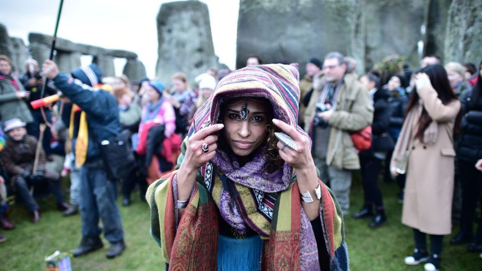 A woman wears a costume as people gather at Stonehenge in Wiltshire western England.