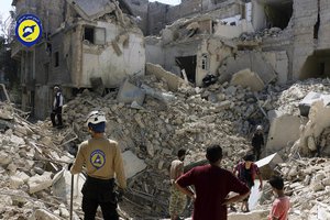 In this picture taken, Tuesday, Oct. 11, 2016, provided by the Syrian Civil Defense group known as the White Helmets, Syrian Civil Defense workers search through the rubble in rebel-held eastern Aleppo, Syria.