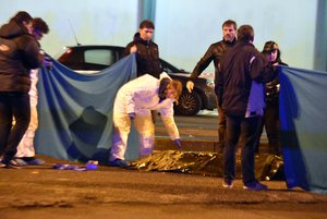 Italian police cordon off an area around a body after a shootout between police and a man in Milan's Sesto San Giovanni neighborhood, Italy, early Friday, Dec. 23, 2016.