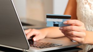 Woman making an online booking with a credit card and a laptop. 