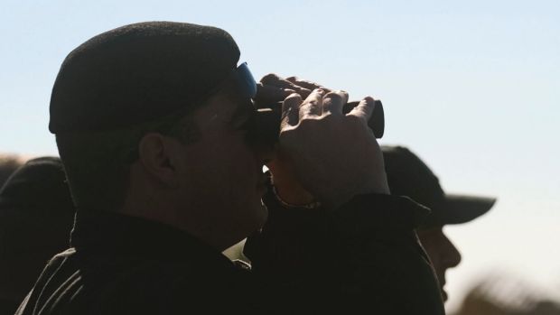 An official looks through his binoculars at an Afriqiyah Airways plane on the tarmac at Malta's Luqa International ...