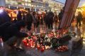 A visitor lays a candle at a makeshift memorial inside the reopened Breitscheidplatz Christmas market.