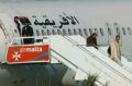 An Afriqiyah Airways plane stands on the tarmac at Malta's Luqa International airport as passengers depart.