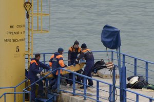 Russian rescue workers attend the scene of the crashed plane at a pier just outside Sochi, Russia, Sunday, Dec. 25, 2016. Russian ships, helicopters and drones are searching for bodies after a plane carrying 92 people crashed into the Black Sea.