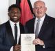 Homesick: James Segeyaro becomes an Australian citizen at a ceremony with Governor General Peter Cosgrove on January 26.