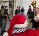 Palestinian protesters, some are dressed as Santa Claus, carry Palestinian flags and chant anti-Israel slogans in front ...