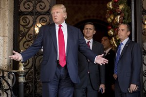 President-elect Donald Trump, left, accompanied by Trump Chief of Staff Reince Priebus, right, and Retired Gen. Michael Flynn, a senior adviser to Trump, center, speaks to members of the media at Mar-a-Lago, in Palm Beach, Fla., Wednesday, Dec. 21, 2016.