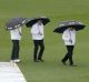 Umpires Mick Martell, left, Richard Kettleborough and Aleem Dar, right, inspect the ground as rain delays play between ...