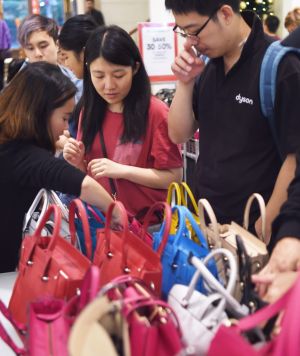 Bargain hunters pore over handbags.