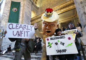 Jo Walter, of Bremerton, Wash., wears a large Donald Trump head mock-up as she protests Electoral College voting Monday, Dec. 19, 2016, in Olympia, Washington, US.