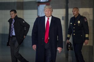 President-elect Donald Trump, center, accompanied by Michael Flynn, President-elect Donald Trump's nominee for National Security adviser, left, and The Ohio State University Chief of Police Craig Stone, right, arrives to speak to members of the media after meeting with families of the victims of the knife attack on Nov. 28.