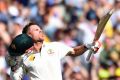 Flying high: David Warner celebrates his century.