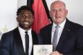 Homesick: James Segeyaro becomes an Australian citizen at a ceremony with Governor General Peter Cosgrove on January 26.