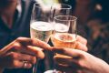 Three female friends celebrating with champagne. They are sitting in a bar and toasting with glasses of champagne. ...