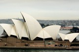 SYDNEY, NSW - JULY 08: The aircraft carrier USS Kitty Hawk (L) sails past the Sydney Opera House on it's way out of ...