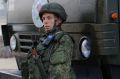 A Russian soldier stands next to an aid convoy in Aleppo.