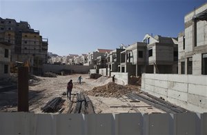 File - Palestinians laborers work at a construction site in the Jewish West Bank settlement of Maale Adumim, near Jerusalem. Tuesday, Sept. 16, 2014. Israel's settler population in the West Bank increased by 2 percent in the first half of the year, an advocacy group announced Tuesday, signaling robust growth in the settlements even while Israel was conducting peace talks with the Palestinians.