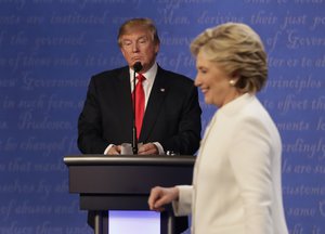 File - In this Oct. 19, 2016 file photo, Republican presidential nominee Donald Trump waits behind his podium as Democratic presidential nominee Hillary Clinton makes her way off the stage following the third presidential debate at UNLV in Las Vegas.