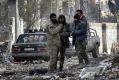 Syrian troops and pro-government gunmen stand in the Ansari neighbourhood, east Aleppo.