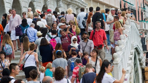 Tourists crowd on one of the bridges along Molo San Marco in Venice, Italy.