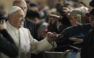 Pope Francis holds hands with faithful after celebrating a new year's eve vespers Mass in St. Peter's Basilica at the Vatican