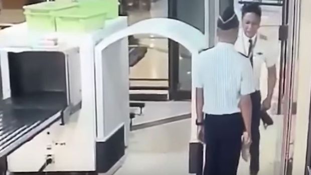 The video shows the pilot staggering through security at Surabaya airport.