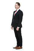 Cheerful businessman standing and looking away