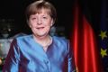 German Chancellor Angela Merkel poses for photographs after the television recording of her annual New Year's speech.