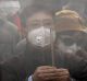 Chinese worshippers wearing masks burn incense while offering prayer at Beijing's Yonghegong Lama Temple as the Chinese ...