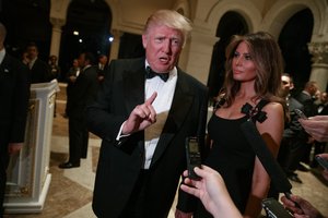 Melania Trump, right, looks on as her husband President-elect Donald Trump talks to reporters during a New Year's Eve party at Mar-a-Lago, Saturday, Dec. 31, 2016, in Palm Beach, Fla.