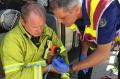 ACT Fire & Rescue senior firefighters?Michael Henriksen and?Vic Lourandos use an oxygen mask to resuscitate Moke the cat ...