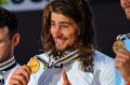 Golden glow: Peter Sagan (centre) celebrates his win in the road race at the 2016 Road World Championships in Doha.