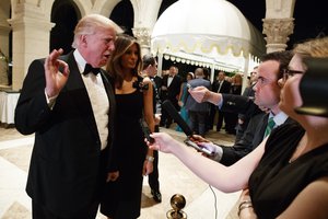 Melania Trump, right, looks on as her husband President-elect Donald Trump talks to reporters during a New Years Eve party at Mar-a-Lago, Saturday, Dec. 31, 2016, in Palm Beach, Fla.