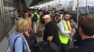 Passenger queue for Virgin Australia snakes outside the domestic terminal at Sydney Airport.