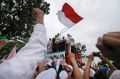 Muslim protesters raise their fists as the leader of Islamic Defenders Front, Rizieq Shihab, gives a speech during a ...