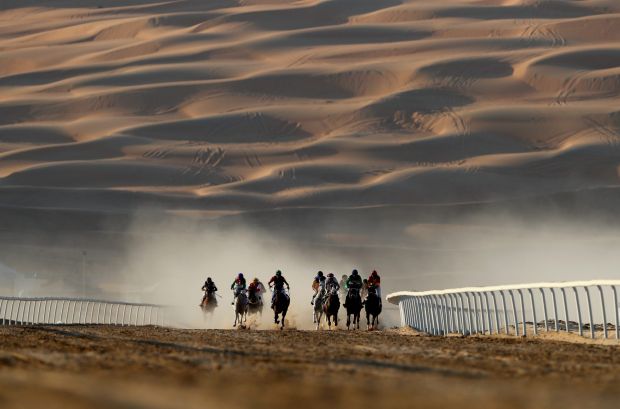 Horses and jockeys in action during the Liwa Sports Festival at Moreeb Dune in Abu Dhabi, United Arab Emirates.