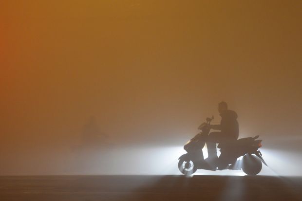 A man rides a scooter on a street blanketed by severe smog in Fuyang in central China's Anhui province.